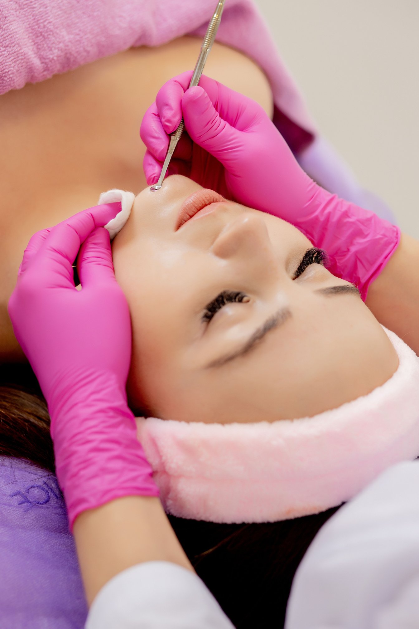 Cosmetologist at spa beauty salon doing acne treatment using